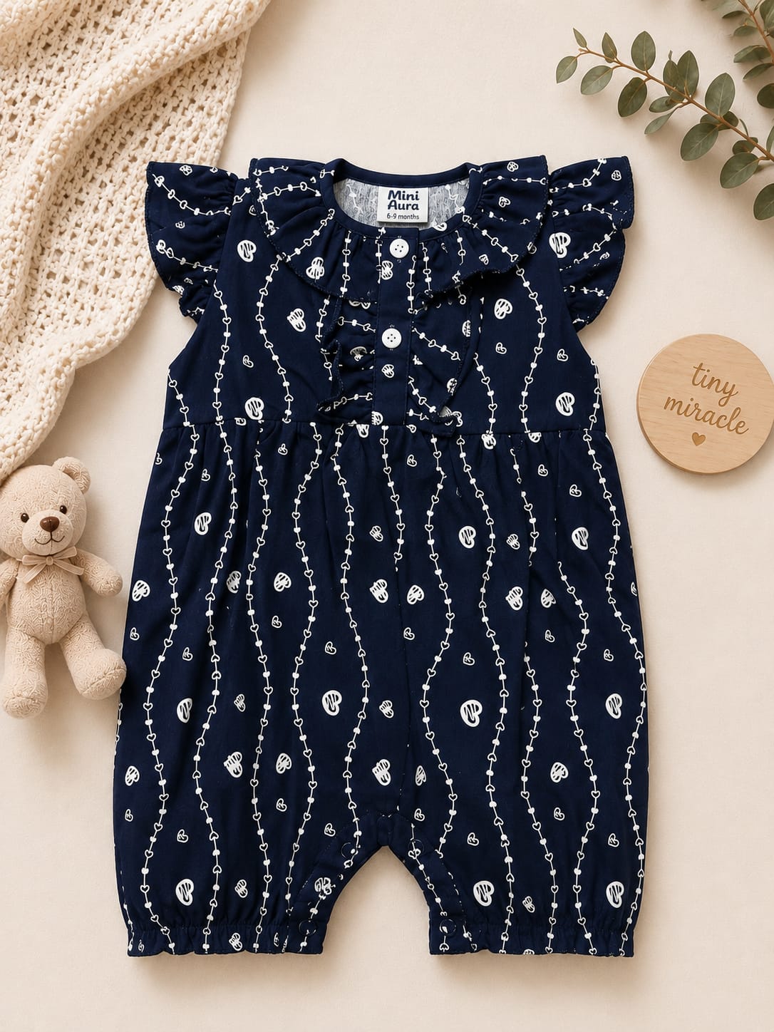 Baby girl navy blue sleeveless romper with white heart stripe print and ruffle collar.