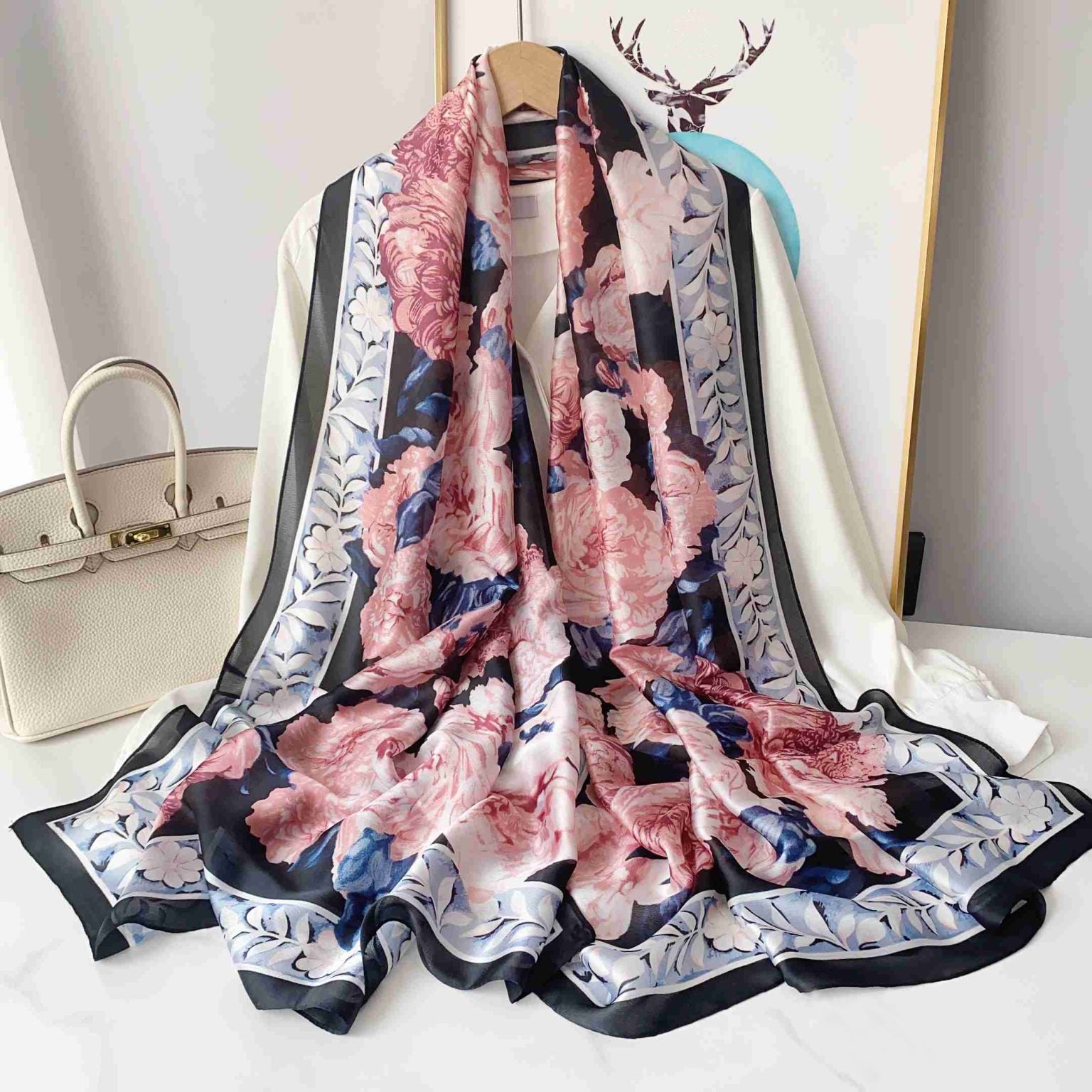 Blush pink silk-satin scarf featuring a large peony floral print on a navy background with a decorative light blue floral border