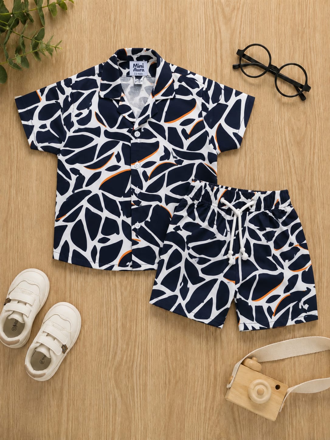 Boys navy blue and white giraffe abstract print short-sleeve button-down shirt and matching shorts set.