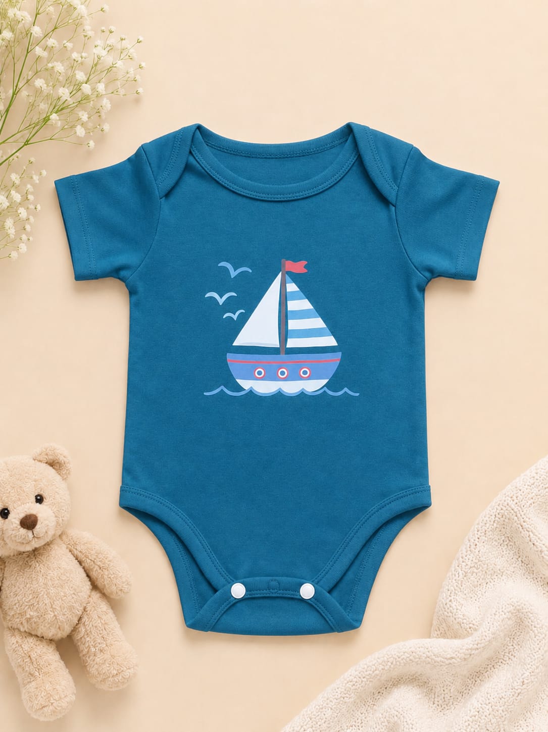 Teal blue short-sleeve baby bodysuit featuring a cartoon sailboat and seagulls graphic by NIFTY.