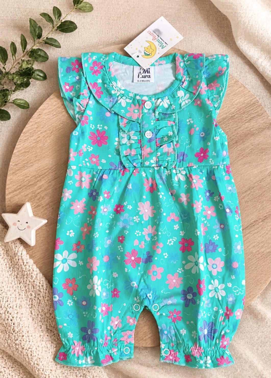 Baby girl mint green sleeveless romper with pink and purple floral print and ruffle collar.