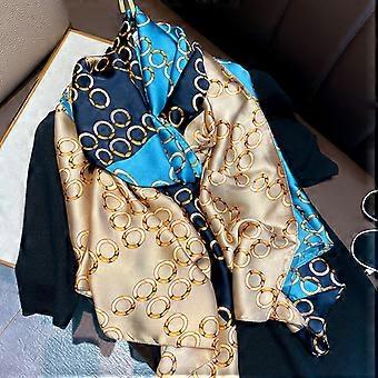 Luxury silk-satin scarf featuring a repeating gold interlocking chain motif on navy blue, teal, and champagne panels